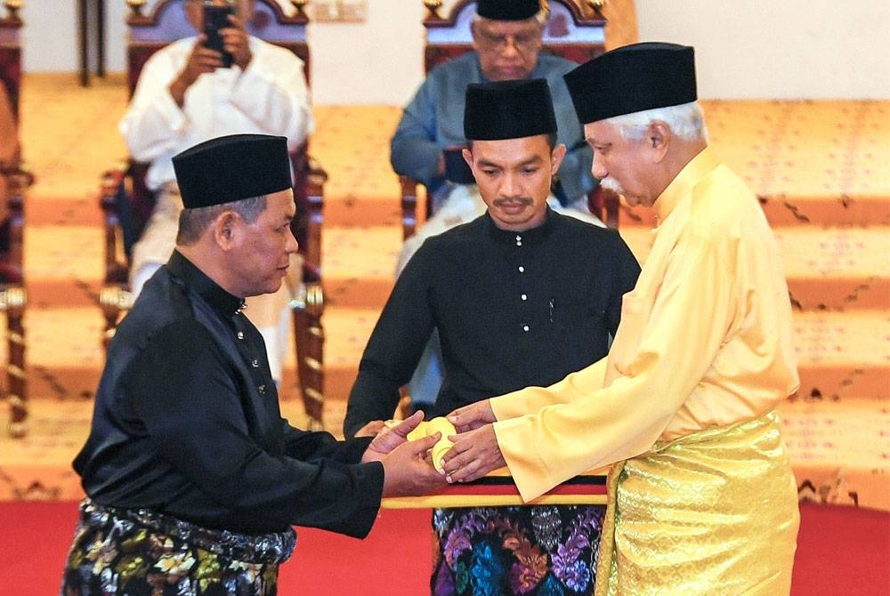 Tuanku Muhriz berkenan menyerahkan watikah pelantikan kepada Aminuddin sebagai Menteri Besar Negeri Sembilan pada Istiadat Penyerahan Watikah, Pelantikan dan Mengangkat Sumpah Menteri Besar Negeri Sembilan di Balairung Seri Istana Besar Seri Menanti pada Isnin - Foto: Bernama