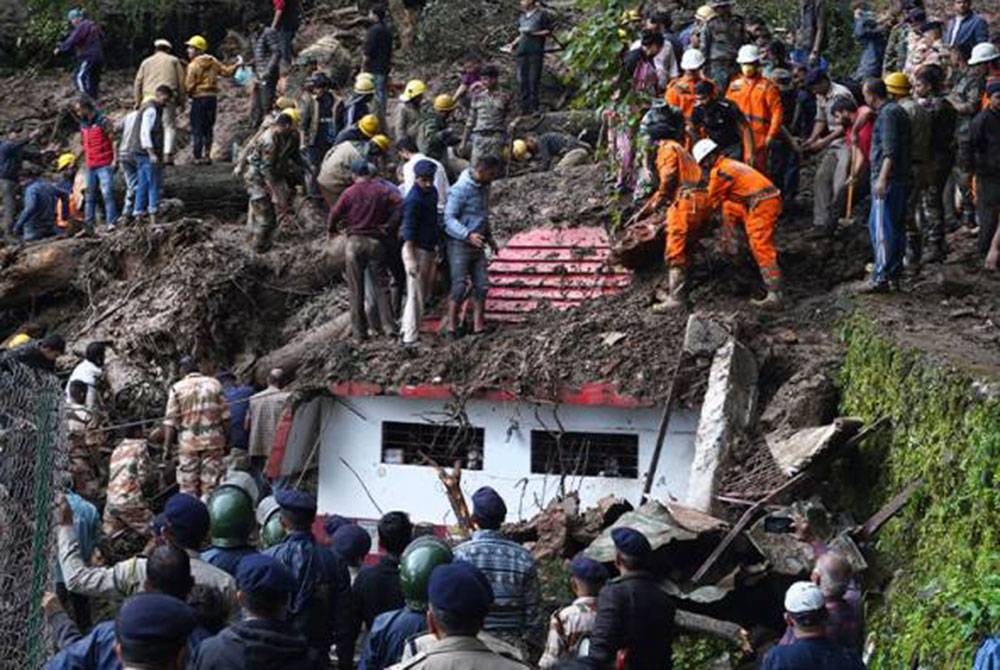 Anggota keselamatan jalankan kerja-kerja mencari dan menyelamat mangsa dikhuatiri terperangkap dalam kejadian tanah runtuh berhampiran sebuah kuil di pinggir Shimla, Himachal Pradesh pada Isnin. - Foto AP