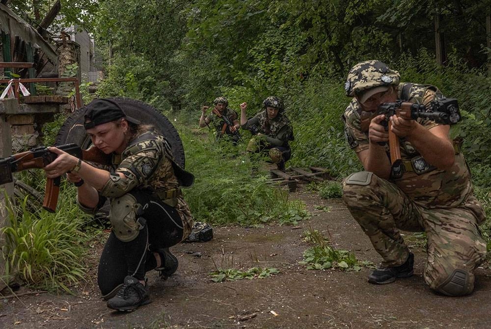 Para peserta mengambil bahagian dalam latihan ketenteraan untuk orang awam selama lima hari, di Kiev pada Jumaat, di tengah-tengah pencerobohan Rusia ke atas Ukraine. - Foto AFP