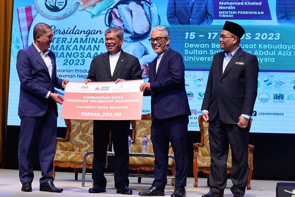 Mohamad Sabu (dua dari kiri) menyaksikan penyerahan replika cek Program Inkubator Usahawan bernilai RM966,250 oleh Presiden yang juga Ketua Pegawai Eksekutif Agrobank, Datuk Tengku Ahmad Badli Shah Raja Hussin (dua, kanan) kepada Naib Canselor UPM, Prof Datuk Dr Mohd Roslan Sulaiman (kiri) pada Rabu. - Foto: Bernama