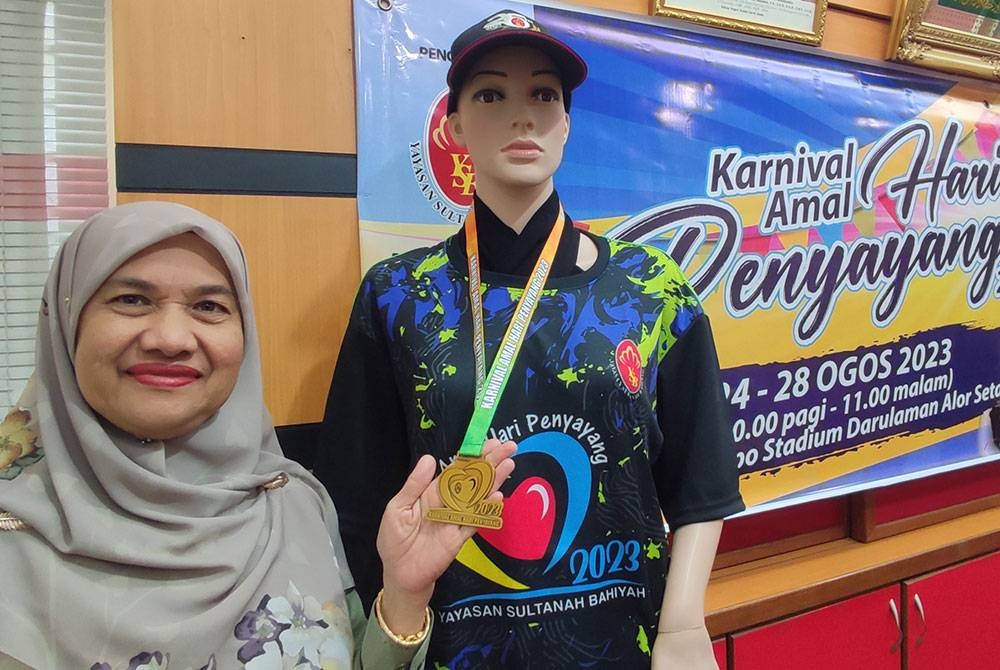 Pengurus Besar YSB, Misbah Abdul Hamid menunjukkan baju-T dan medal disediakan bersempena Karnival Amal Hari Penyayang ketika ditemui pemberita di Pejabat YSB,di sini, pada Khamis.