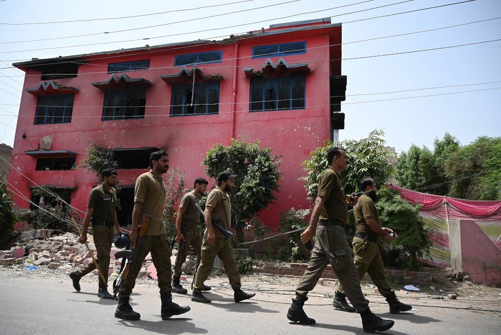 Pasukan polis tiba di gereja Salvation Army yang dibakar di Jarawala, Pakistan. - AFP