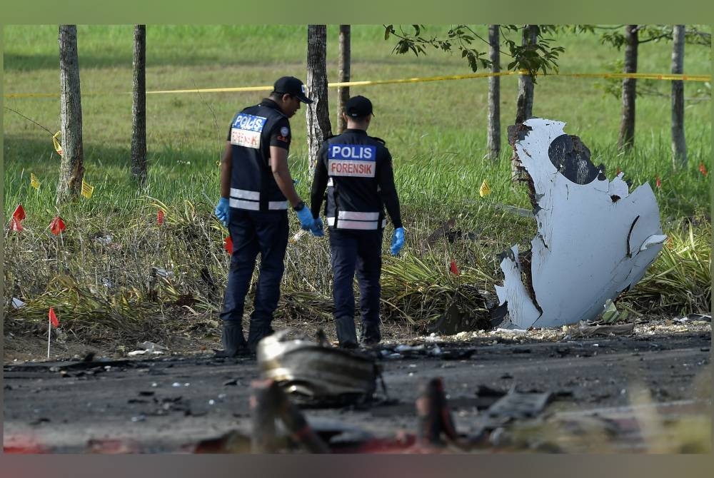 Unit Forensik Polis Diraja Malaysia melakukan siasatan di lokasi kejadian pesawat terhempas di Elmina Shah Alam pada Khamis. - Foto Bernama