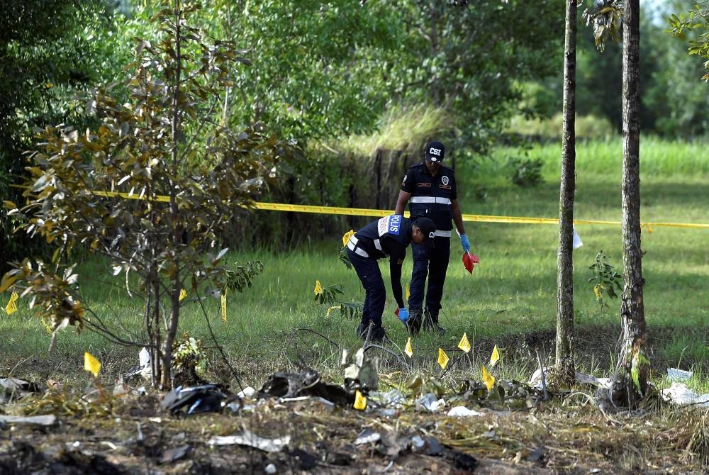 Unit Forensik Polis Diraja Malaysia melakukan siasatan di lokasi kejadian pesawat terhempas di Elmina Shah Alam pada Khamis. - Foto Bernama