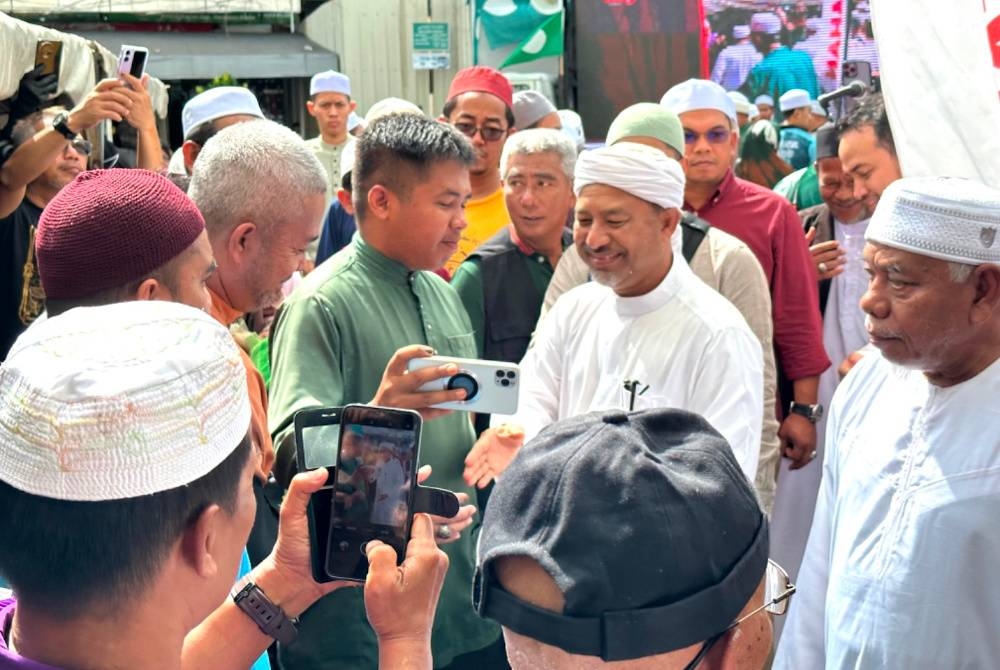 Mohd Nassuruddin (tengah) dikerumuni orang ramai untuk bergambar dan bersalaman.