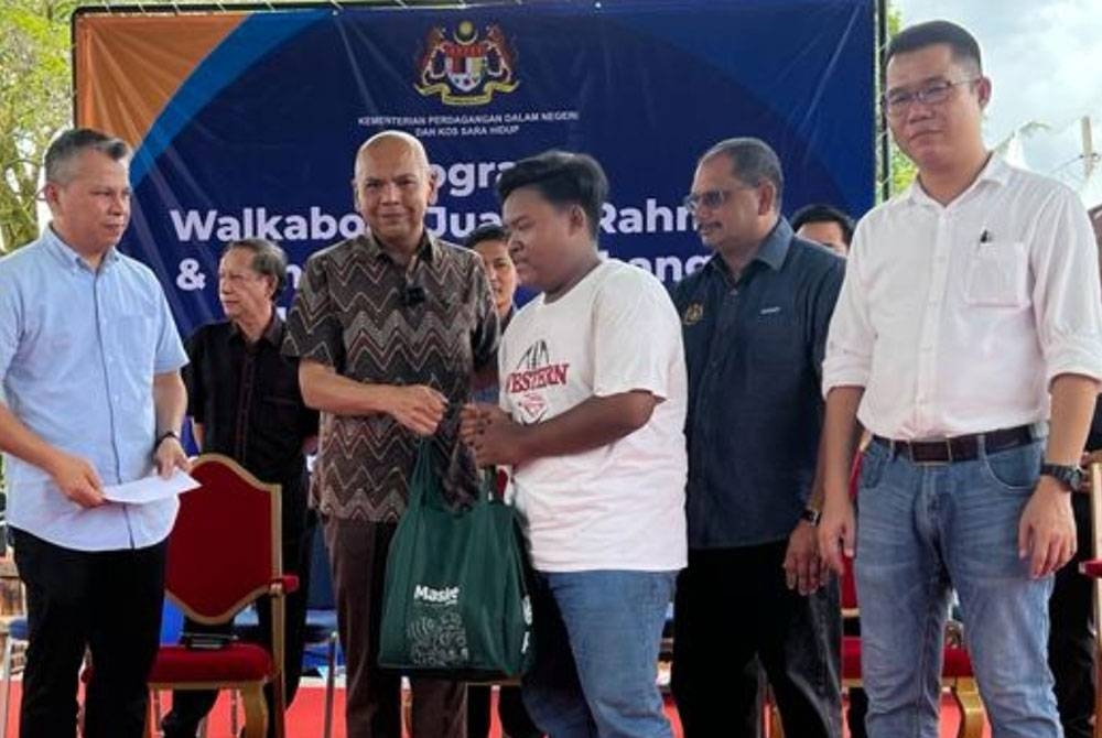 Amirzan menyampaikan sumbangan barangan keperluan asas kepada penerima daripada golongan asnaf pada program berkenaan.