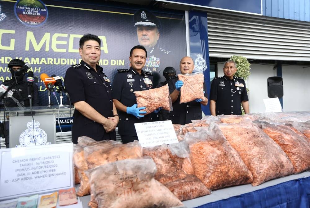 Mohd Kamarudin (dua dari kanan) bersama Ketua Polis Perak, Datuk Seri Mohd Yusri Hassan Basri (dua dari kiri) menunjukkan bungkusan dadah jenis erimin 5 yang dirampas dalam serbuan di Chemor, Ipoh.