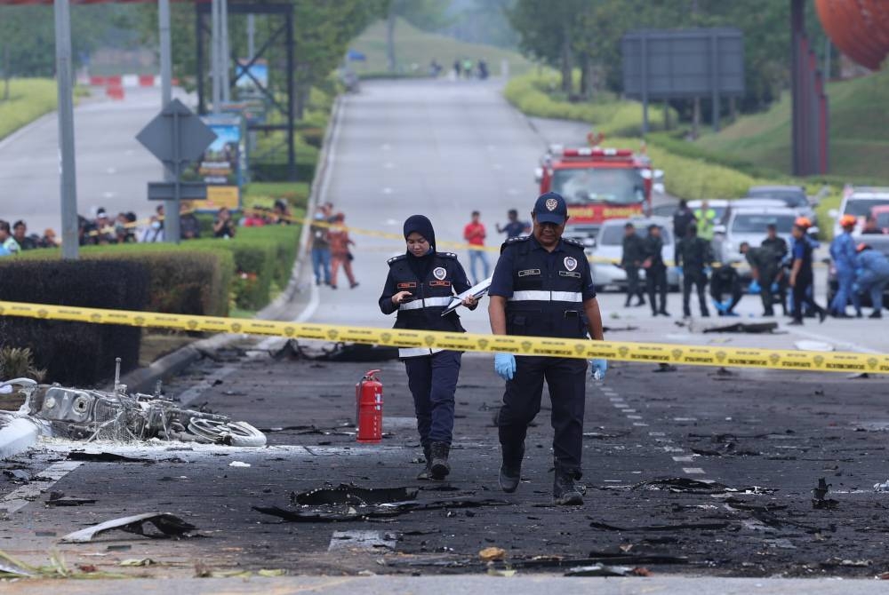 Anggota pasukan forensik Polis Diraja Malaysia menjalankan pemeriksaan di lokasi kejadian pesawat terhempas di Lebuhraya Guthrie berdekatan Bandar Elmina. - Foto Bernama