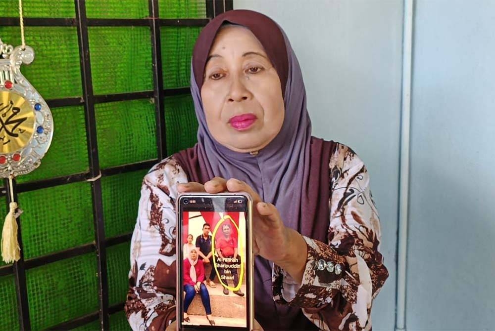 Maznah menunjukkan gambar Allahyarham Sharipuddin yang berasal dari Arau, Perlis antara 10 mangsa yang maut dalam tragedi nahas pesawat terhempas di Elmina, Seksyen U16, Shah Alam pada Khamis.