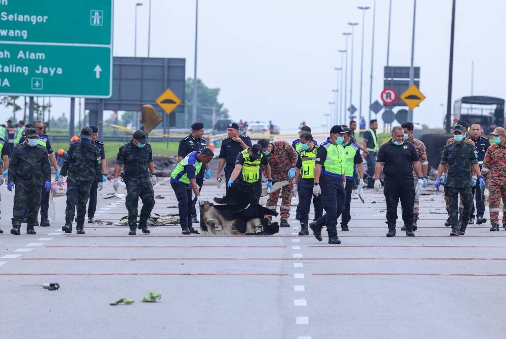 Anggota polis menjalankan pemeriksaan di lokasi kejadian pesawat terhempas di Lebuhraya Guthrie berdekatan Bandar Elmina pada Jumaat. - Foto Bernama