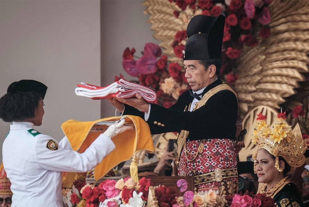 Jokowi menyerahkan bendera Indonesia sebelum ia dinaikkan semasa upacara memperingati Hari Kemerdekaan ke-78 negara itu di Istana Presiden.