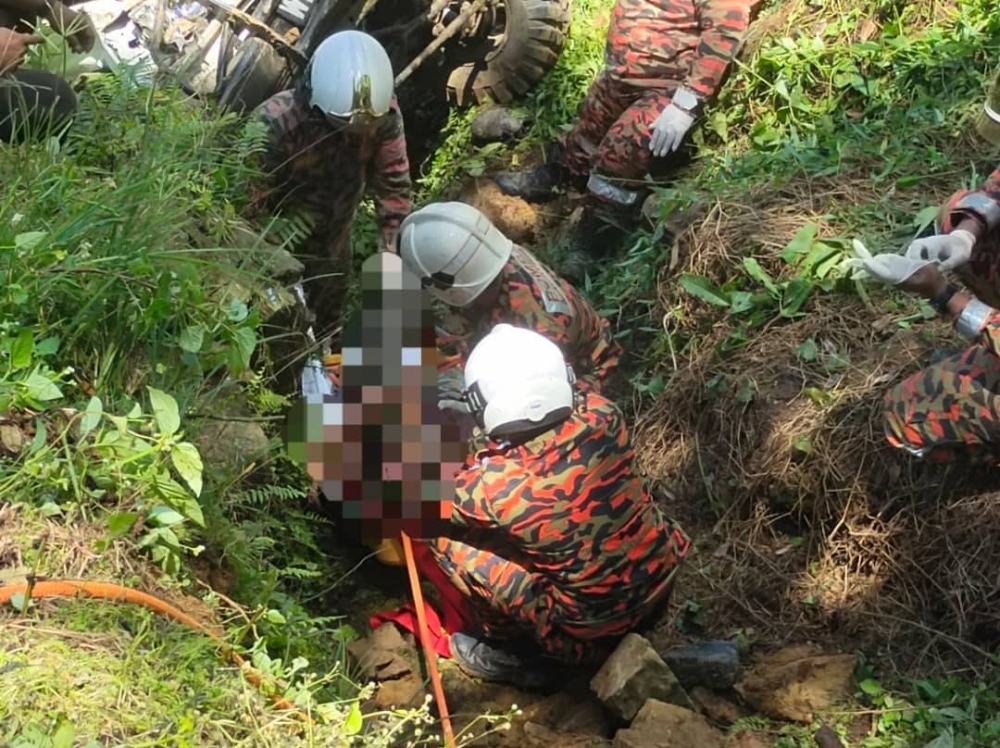 Anggota bomba membantu membawa naik mayat mangsa yang terjatuh ke dalam gaung di jalan kebun, Sungai Pertam, Sungai Ruan, Raub pada Sabtu.