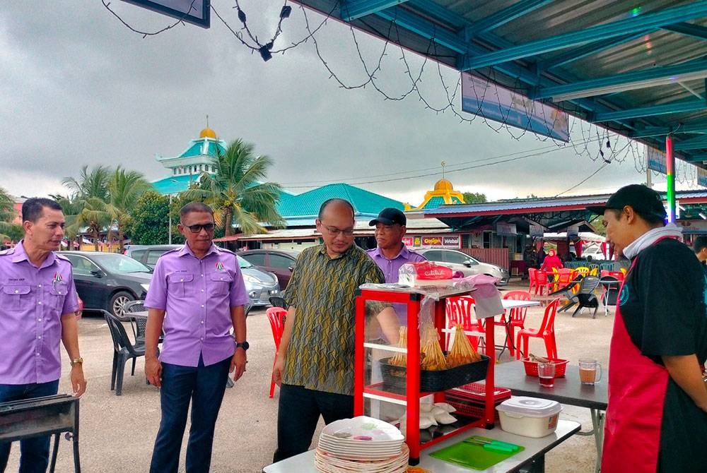 Amzah (kiri) ketika mengiringi Hafizal (tiga dari kiri) melawat gerai-gerai niaga yang diwujudkan di Masjid Nur Sa&#039;adah Pengkalan Batu di sini, pada Sabtu.