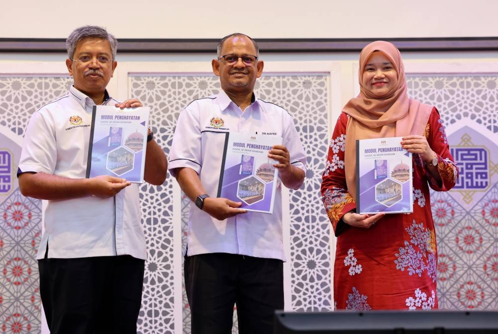 Fadhlina (kanan) menunjukkan buku modul penghayatan hadis 40 Imam Nawawi selepas melancarkannya pada Sabtu semasa Program Karnival Penghayatan Hadis 40 Imam Nawawi di Sekolah Menengah Kebangsaan Agama Putrajaya (SMKA). Turut kelihatan, Timbalan Ketua Pengarah Pendidikan (Sektor Dasar dan Kurikulum) Dr Ahmad Rafee Che Kassim (tengah) dan Pengarah Bahagian Pendidikan Islam Kementerian Pendidikan Abu Hanipah@Fauzi Zahari (kiri). - Foto Bernama