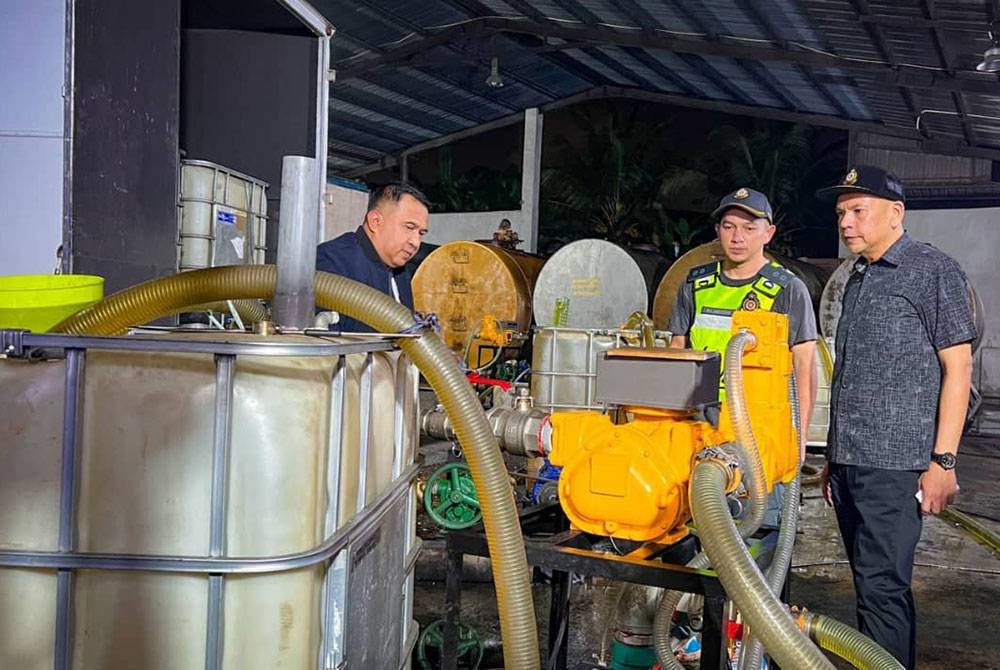 Armizan (kanan) melihat tangki dan peralatan digunakan sindiket menyeleweng diesel bersubsidi di Taman Perindustrian Plentong, Masai ketika Op Tiris pada Sabtu.