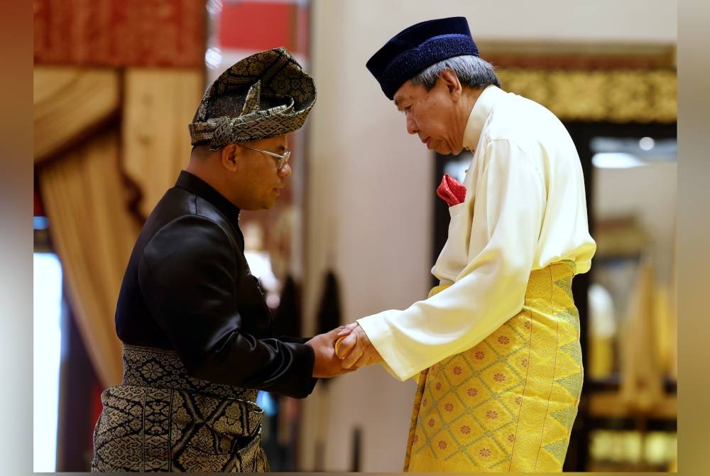 Sultan Sharafuddin (kanan) berkenan mengurniakan Surat Cara Pelantikan Menteri Besar Selangor kepada Amirudin pada Istiadat Angkat Sumpah Jawatan Dan Ikrar Aku Janji Serta Pengurniaan Watikah Pelantikan Yang Amat Berhormat Datuk Menteri Besar Selangor di Istana Alam Shah pada Isnin. - Foto Bernama