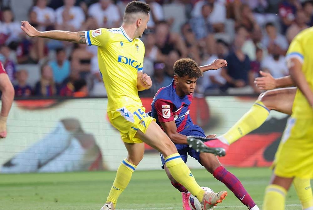 Yamal (tengah) cuba melepasi kawalan pemain Cadiz dalam aksi La Liga di Stadium Olimpic, Barcelona. - Foto AFP