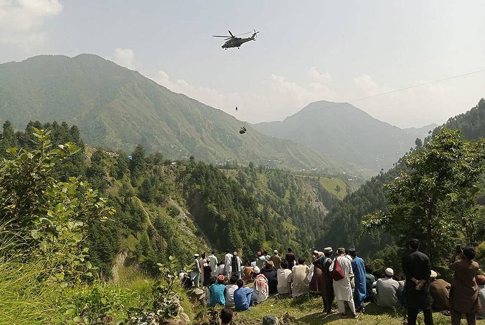 Orang ramai melihat operasi menyelamat lapan mangsa terperangkap dalam kereta kabel di wilayah Khyber Pakhtunkhwa. - Foto AFP