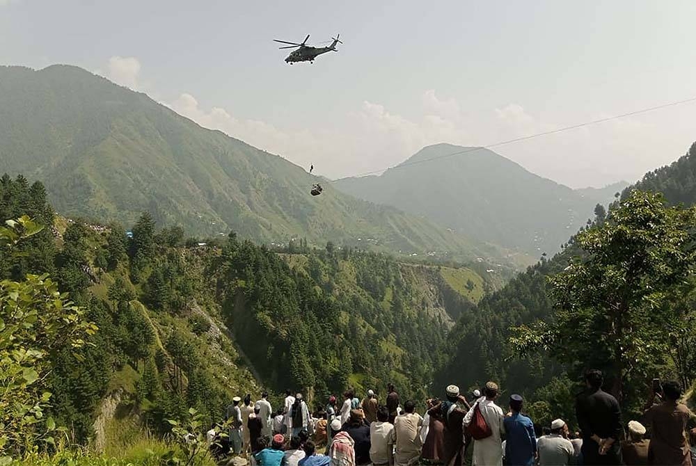 Orang ramai melihat operasi menyelamat lapan mangsa terperangkap dalam kereta kabel di wilayah Khyber Pakhtunkhwa. - Foto AFP