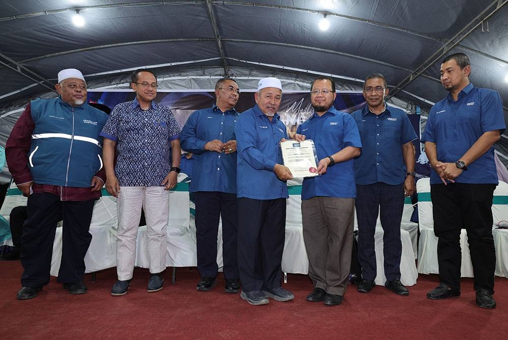 Tuan Ibrahim Tuan (empat, kiri) menyerahkan watikah pelantikan calon kepada calon PN yang akan bertanding bagi Pilihan Raya Kecil (PRK) DUN Simpang Jeram, Prof Madya Dr Mohd Mazri Yahya pada Majlis Pelancaran Jentera dan Pengisytiharan Calon Perikatan Nasional di Markaz Pas Kawasan Bakri, pada Rabu. - Foto Bernama.