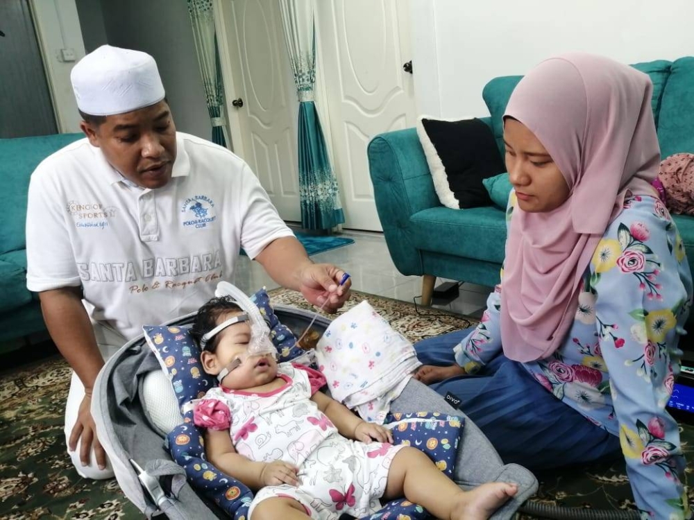 Mohd Shafiq (kiri) bersama isteri, Siti Nasiha Sakinah Md Saied, 33, berada di samping anak mereka, Sufi Syafrina pada Khamis.