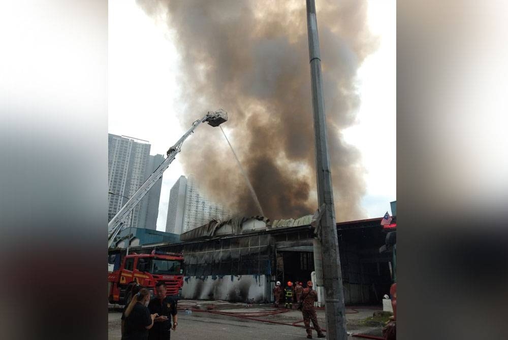 Anggota bomba dan penyelamat memadamkan kebakaran kilang di Kepong di sini pada Khamis.