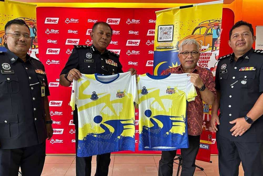 Baharudin (dua dari kiri) bergambar bersama Penasihat Kumpulan Karangkraf, Datuk Hussamuddin Yaacub menunjukkan t-shirt bagi acara kayuhan PDRM Selangor Merdeka Ride and Carnival 2023.