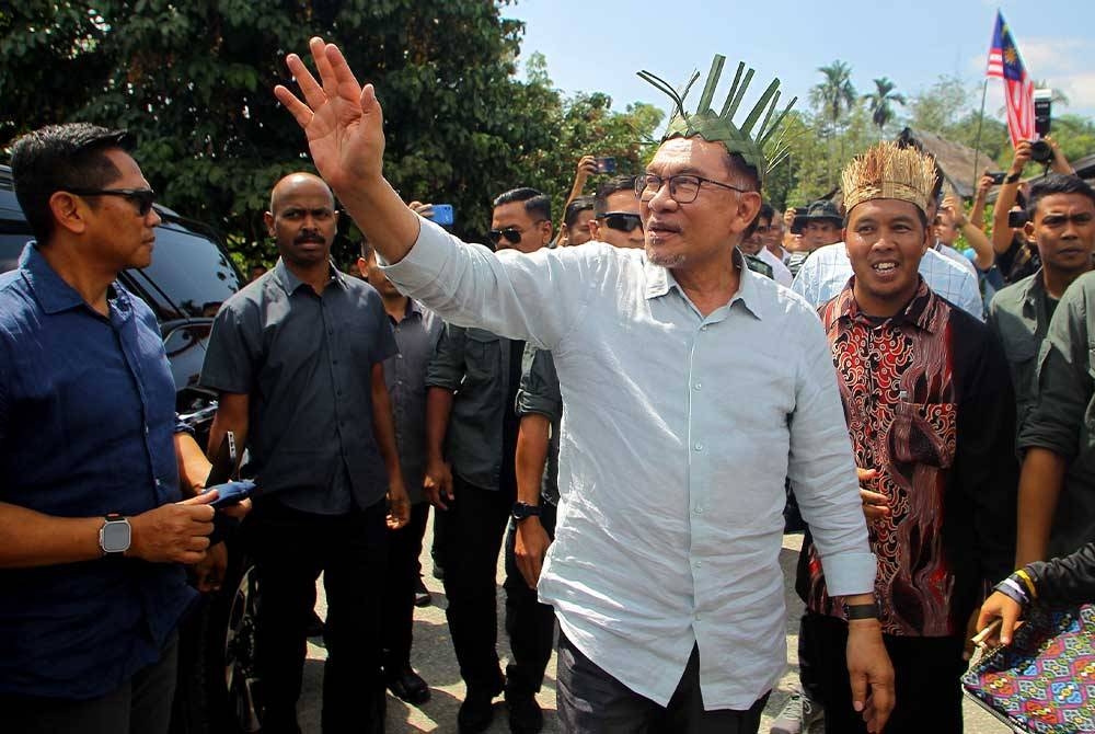 Anwar (tiga dari kanan) ketika hadir pada program lawatan kerja bersama Masyarakat Orang Asli Kampung Tonggang Ulu Kinta pada Khamis. - Foto Bernama