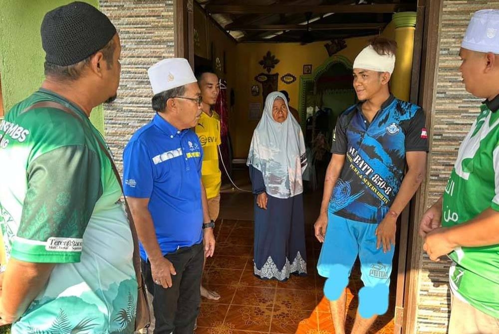 Ahli Dewan Undangan Negeri (ADUN) Telemung, Zawawi Ismail (dua dari kiri) melawat Al Amin Ratna Shariman (dua dari kanan) di kediaman remaja itu di Kampung Lerek, Kuala Berang, Hulu Terengganu. - Foto ihsan Facebook DUN Telemung - Cikgu Awi