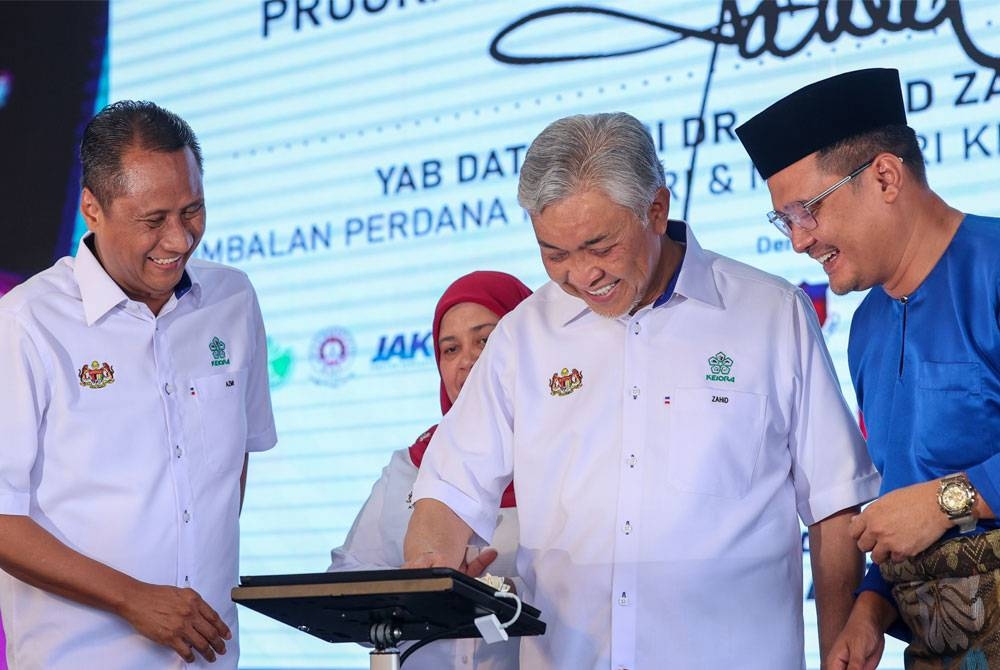 Ahmad Zahid melakukan gimik perasmian sempena Majlis Perasmian Program Belia Desa Madani @ KKDW di B5 Street Market, Pusat Bandar Tampoi Johor Bahru, pada Jumaat. - Foto Bernama