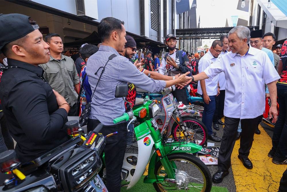 Ahmad Zahid beramah mesra dengan belia yang menyertai pertandingan autoshow motosikal sempena Majlis Perasmian Program Belia Desa Madani @ KKDW di B5 Street Market, Pusat Bandar Tampoi Johor Bahru, pada Jumaat. - Foto Bernama