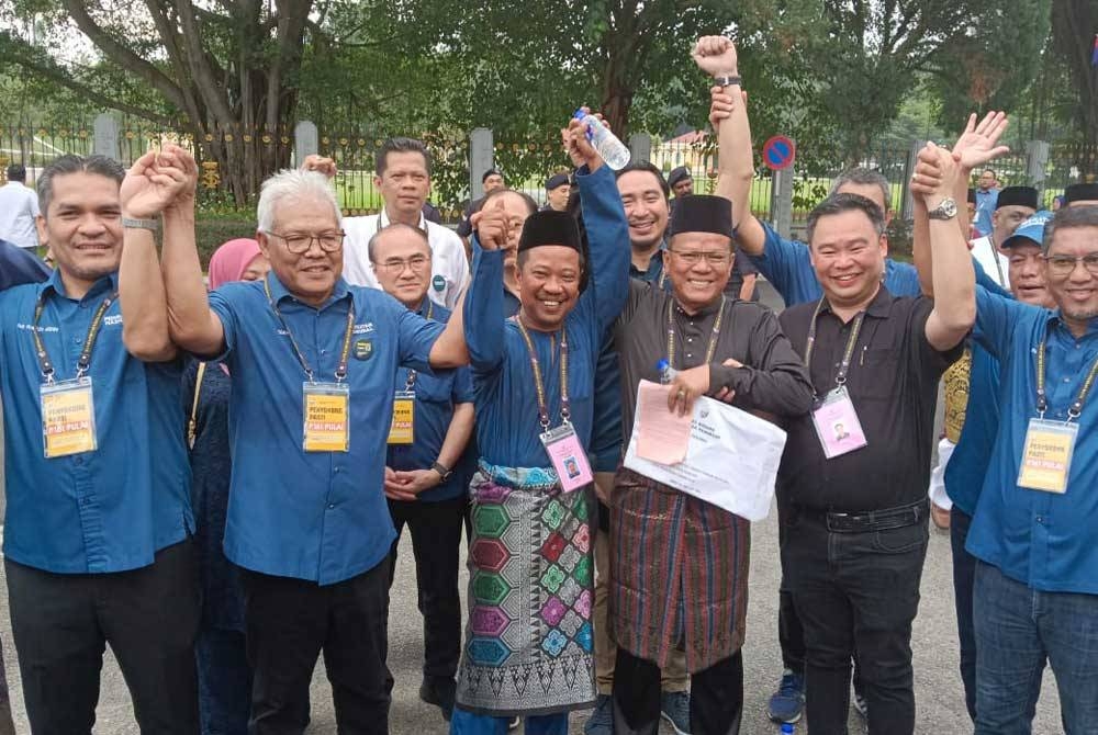 Hamzah mengetuai perarakan bagi mengiringi calon mereka, Zulkifli (tengah) di Pusat Penamaan Calon di Dewan Jubli Intan Sultan Ibrahim, Johor Bahru pada Sabtu.