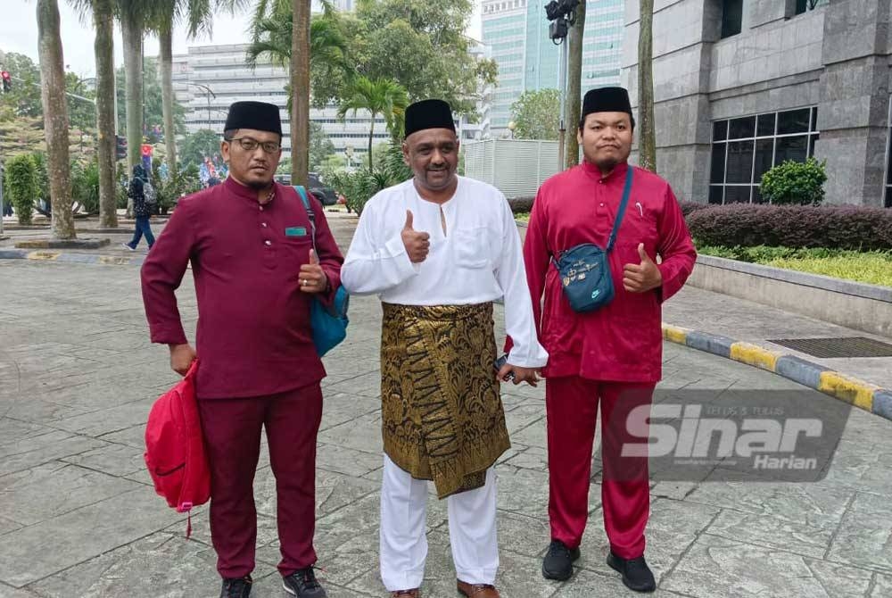 Samsudin (tengah) antara calon PRK Parlimen Pulai yang paling awal tiba untuk penamaan calon di pekarangan Dewan Jubli Intan Sultan Ibrahim, Johor Bahru pada Sabtu.