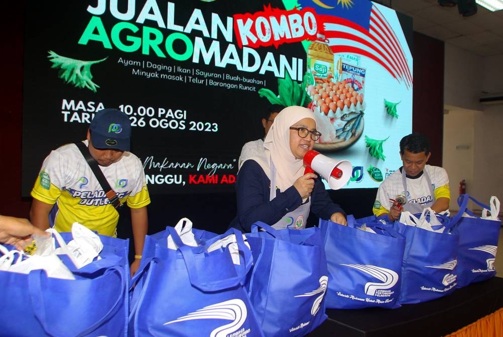 Azulita (dua dari kanan) melakukan lelongan kombo pelbagai jenis barangan keperluan harian dengan harga RM60 pada Program Jelajah Jualan Agro MadaniI Peladang Outlet Usahawan LPP Perak di Dewan Dato Zainal Abidin Zin, hari ini. - Foto Bernama