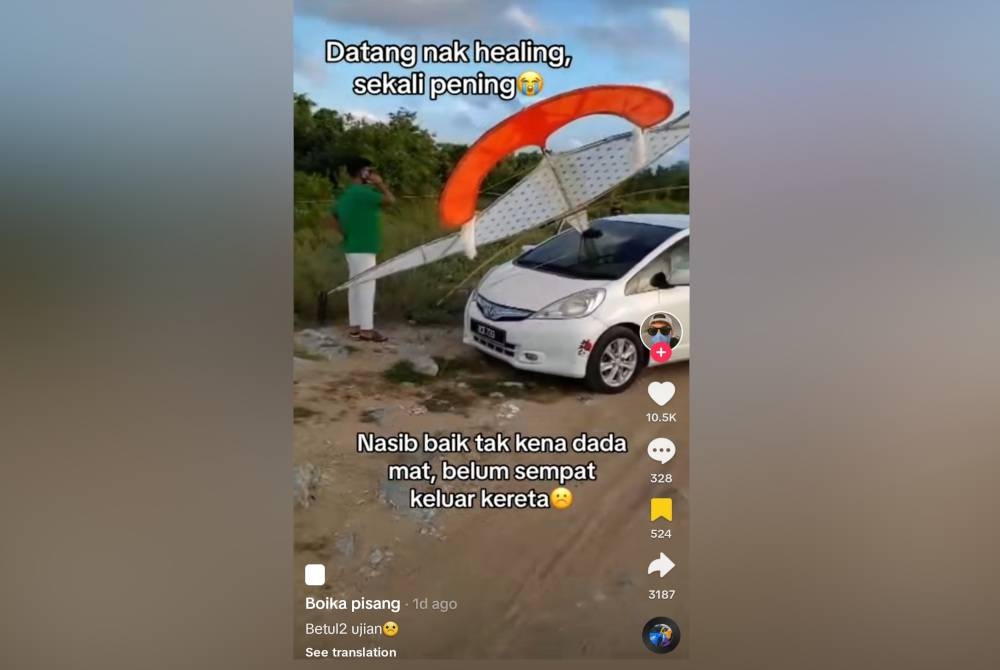 Wau bulan menembusi cermin depan kereta seorang pengguna TikTok.