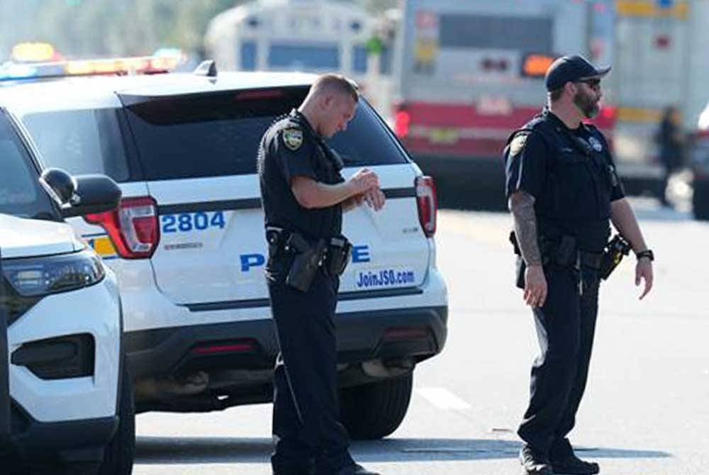 Anggota polis meningkatkan kawalan keselamatan di kawasan kejadian tembakan yang menyebabkan tiga orang terbunuh di Jacksonville, Florida, Amerika Syarikat pada Sabtu. - Foto AP