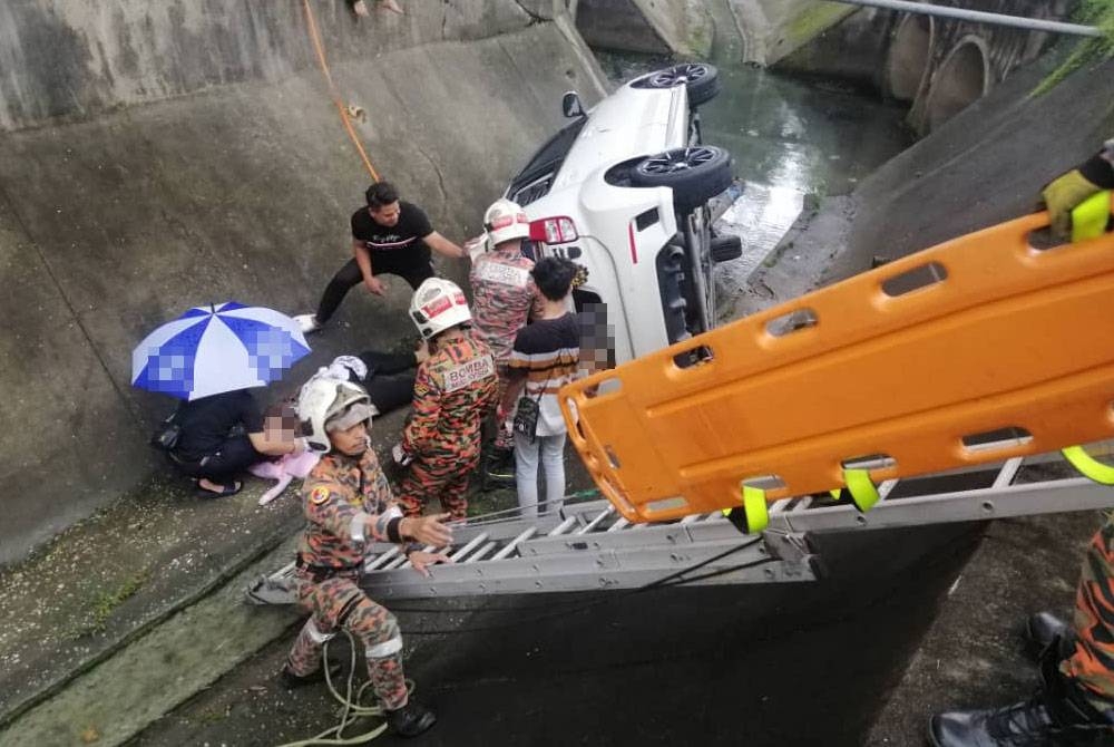 Anggota Bomba dan Penyelamat mengeluarkan seorang wanita yang cedera selepas kereta dipandunya terjatuh ke dalam longkang di Seksyen 18 pada Ahad.