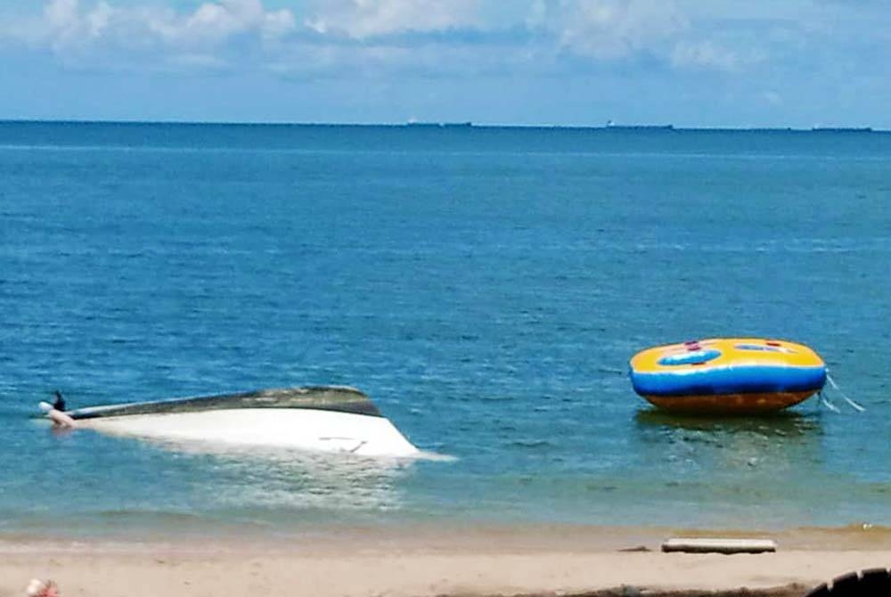 Keadaan bot penumpang yang terbalik di Pantai Teluk Batik kira-kira sembilan meter dari persisir pantai pada Isnin. Foto: Bomba Perak