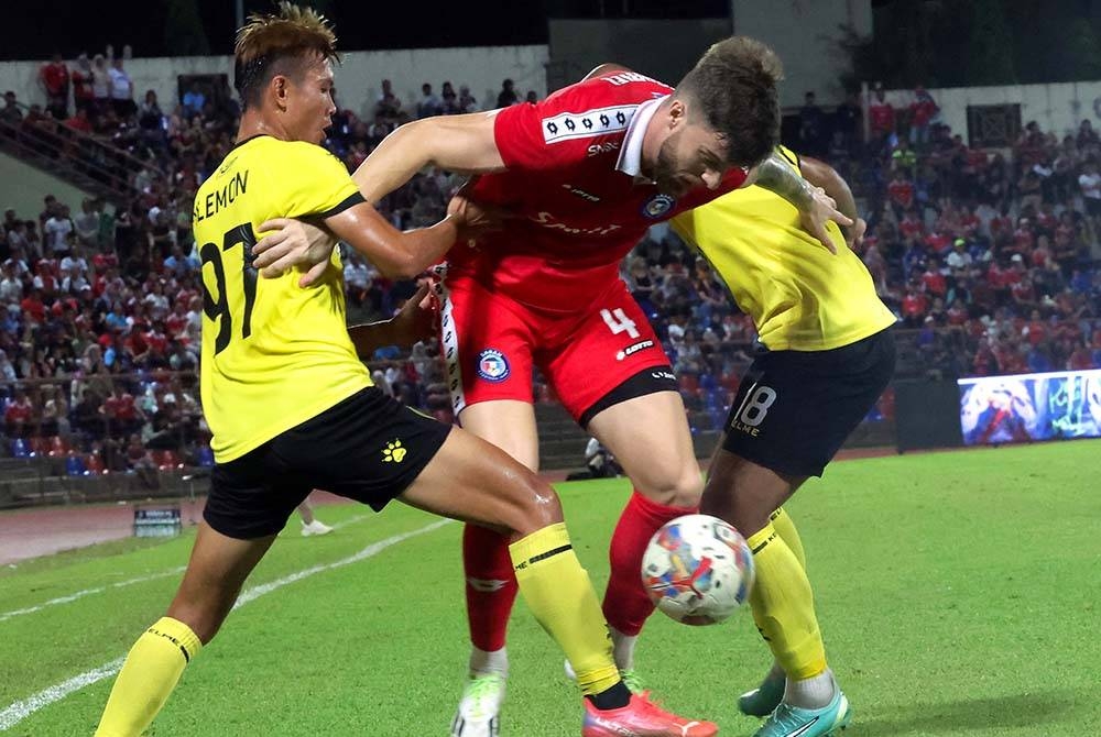 Pemain Sabah, Gabriel Schmegel Wotter cuba melepasi kawalan dua pertahanan Negeri Sembilan dalam saingan Liga Super di Stadium Likas. - Foto: Bernama