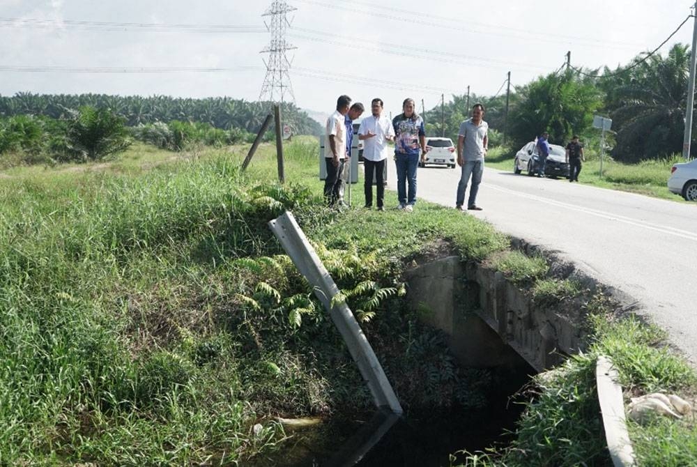 Harrison (tiga dari kanan) meninjau laluan kecil sepanjang 10 meter yang tiada pengadang kiri dan kanan di Jalan Akob Bukit Kerayong, Jeram pada Selasa.