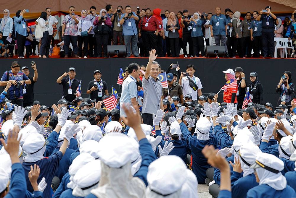 Fahmi (tengah) beramah mesra bersama peserta persembahan semasa hadir menyaksikan perjalanan raptai penuh sambutan Hari Kebangsaan 2023 di Dataran Putrajaya hari ini. - Foto Bernama