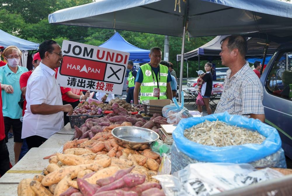 Suhaizan (dua dari kiri) beramah mesra bersama para peniaga ketika berkempen bagi PRK Parlimen Pulai di Pasar Malam Taman Tan Sri Yaacob hari ini. - Foto Bernama