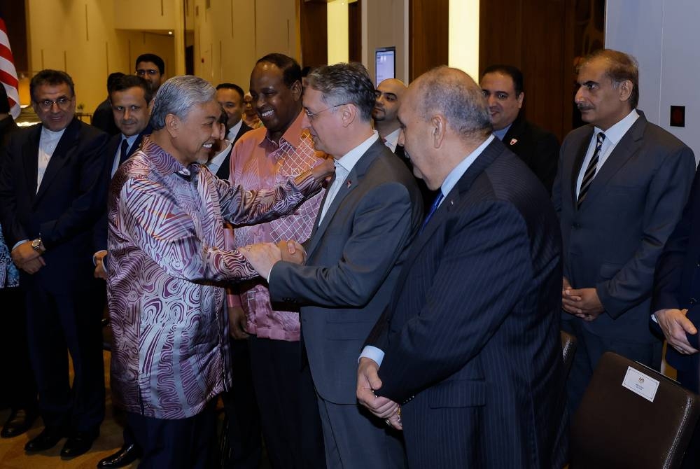 Ahmad Zahid beramah mesra bersama duta dan wakil dari negara anggota OIC yang hadir pada Majlis Makan Malam Perpaduan OIC untuk Al-Aqsa di Putrajaya hari ini. - Foto Bernama