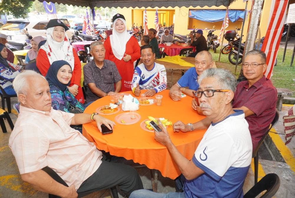 Zulkifli (duduk, tengah) bertemu orang ramai semasa berkempen di kawasan flat di Kempas, Johor Bahru.