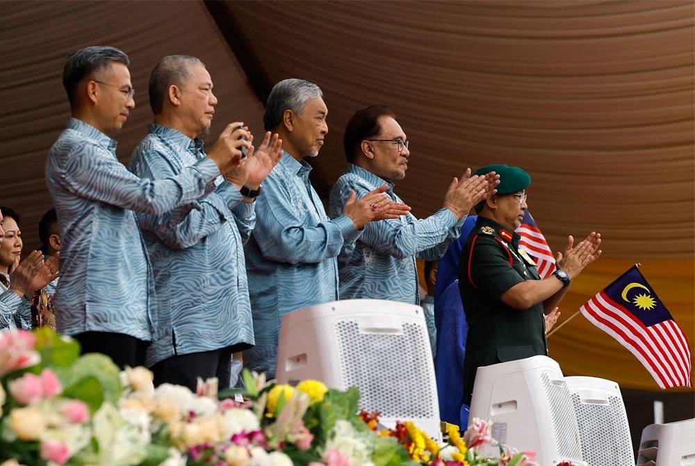 Yang di-Pertuan Agong Al-Sultan Abdullah Ri&#039;ayatuddin Al-Mustafa Billah Shah ketika berkenan menyaksikan acara perbarisan dan perarakan pada sambutan Hari Kebangsaan Ke-66 di Dataran Putrajaya hari ini. Turut sama Perdana Menteri Datuk Seri Anwar Ibrahim, Timbalan Perdana Menteri Datuk Seri Ahmad Zahid Hamidi dan Datuk Seri Fadillah Yusof serta Menteri Komunikasi dan Digital Fahmi Fadzil. - Foto Bernama.