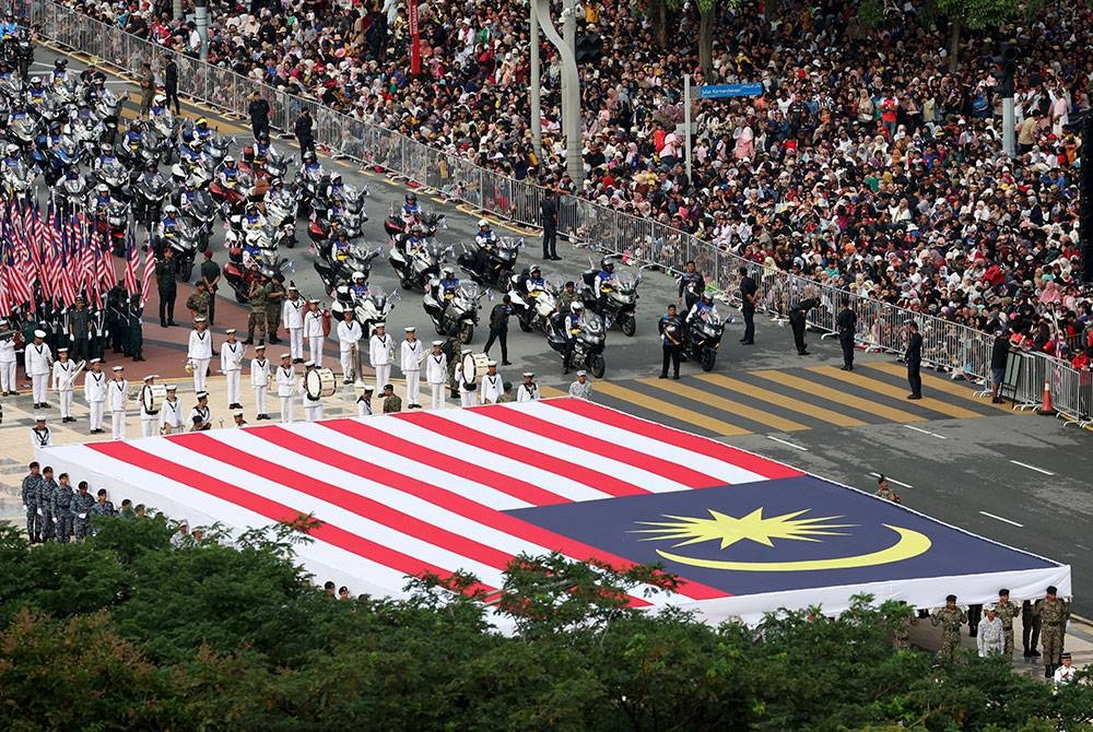 Perarakan kontinjen pembawa Jalur Gemilang bersaiz 24.4 meter x 12.2 meter oleh 100 pegawai kadet Akademi Latihan Ketenteraan, Universiti Pertahanan Nasional Malaysia (UPNM) pada sambutan Hari Kebangsaan Ke-66 bertemakan "Malaysia Madani:Tekad Perpaduan Penuhi Harapan” di Dataran Putrajaya pada Khamis. - Foto Bernama.