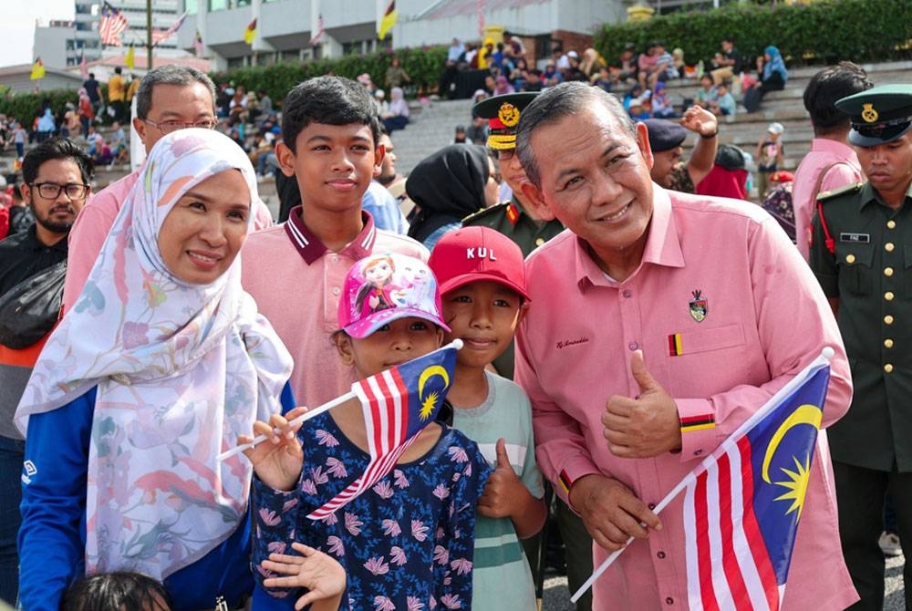 Aminuddin (kanan) berkesempatan beramah mesra dengan orang ramai pada sambutan tersebut pada Khamis.