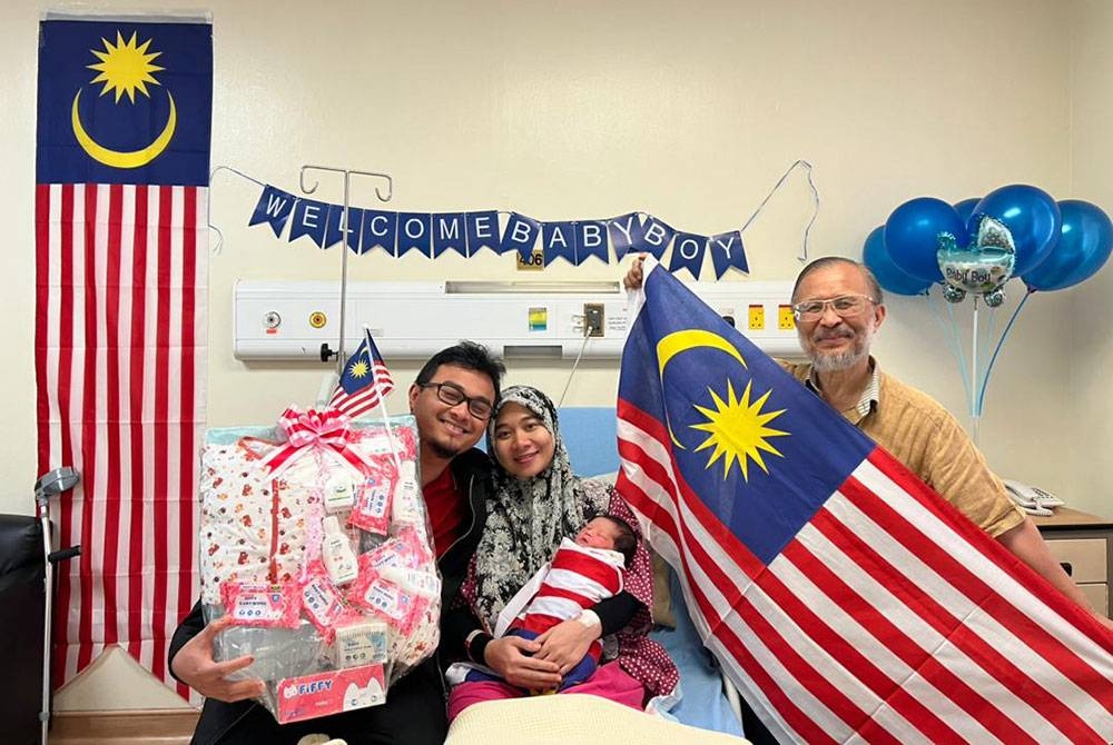 Nur Amirah memangku bayinya yang dilahirkan pada jam 12.05 tengah malam ketika sambutan Hari Kebangsaan negara.