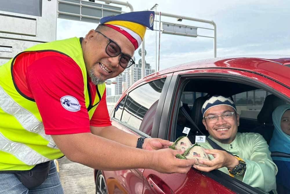 Pengagihan nasi lemak percuma kepada pengguna jalan raya sempena Hari Kebangsaan. - Foto Prolintas