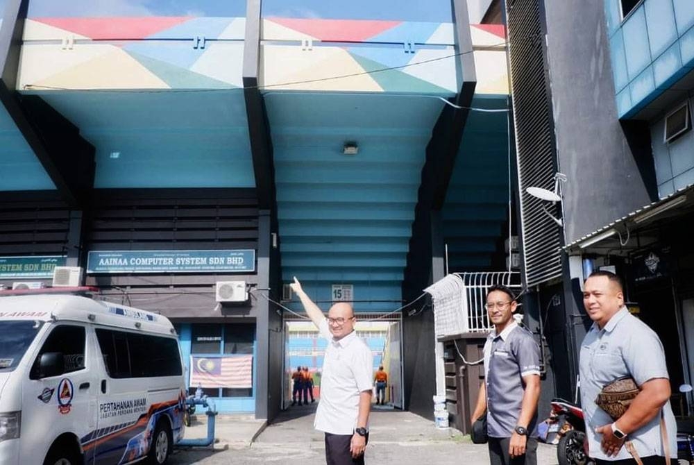 Fadzli (kiri) bersama Izad ketika meninjau kerja-kerja mengecat di luar Stadium Darul Makmur.